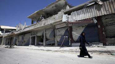 Un Syrien marche dans une rue dévastée de Qousseïr le 1er août 2013 [Joseph Eid / AFP]