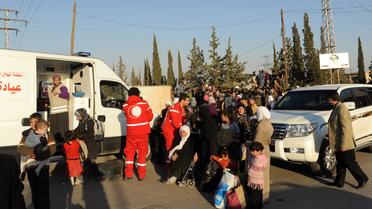 Des membres du Croissant rouge syrien évacuent des femmes et des enfants dans une banlieue de Damas, le 12 octobre 2013  [- / Sana/AFP]