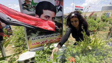 Une femme syrienne pleure sur la tombe d'un proche, enterré au cimetière des "Martyrs" à Tartous à l'ouest de Damas, le 18 mai 2014 [Joseph Eid / AFP]