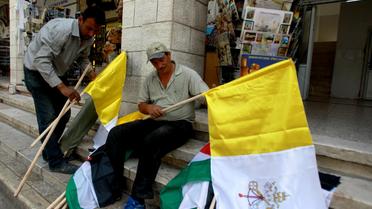 Des employés municipaux préparent des drapeaux du Vatican et la Palestine avant l'arrivée du pape François en Terre sainte, le 22 mai 2014 à Bethléem   [Musa Al-Shaer / AFP]