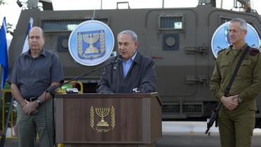 Le Premier ministre Benjamin Netanyahu avec le général de l'armée Benny Gantz (d) et le ministre de la Défense Moshe Ya'alon (l), s'adresse à des militaires, le 19 juin 2014 depuis un camp militaire en Cisjordanie [Jim Hollander / POOL/AFP/Archives]