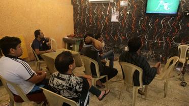 L'Irakien Raad Abdul Hussein et ses amis devant la Coupe du monde de football, le 1er juillet 2014 au "Facebook café" de Bagdad. [Ahmad Al-Rubaye / AFP]