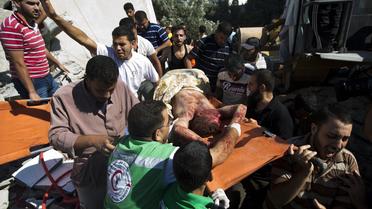 Le corps d'un homme retiré de gravas après un bombardement israélien sur le camp de réfugiés de  Maghazi dans la bande de Gaza, est transporté, le 9 juillet 2014  [Mahmud Hams / AFP]