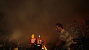 Des pompiers tentent d'éteindre un incendie d'une usine de savon à la suite d'un bombardement israélien, le 10 août 2014 sur la bande Gaza [Mohammed Abed / AFP]