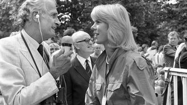 Le journaliste hippique André Théron s'entretient avec l'athlète française Marie-Christine Debourse le 2 août 1984 sur l'hippodrome de Deauville [Mychele Daniau / AFP/Archives]