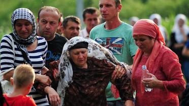 Une vieille dame, survivante du massacre de Srebrenica, est emmenée aux urgences après s'être évanouie, le 10 juillet 2013 au cimetière de Potocarion, près de Srebrenica [Elvis Barukcic / AFP]