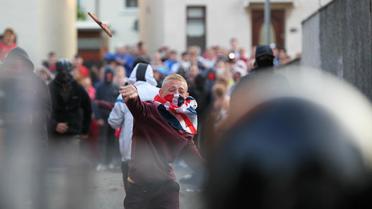 Un manifestant lance un objet en direction de la police, le 13 juillet 2013 lors de violences à Belfast [Peter Muhly / AFP]