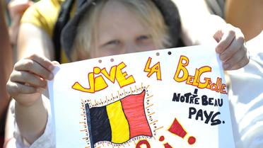 Un jeune garçon brandit un dessin surleque est inscrit "Vive la Belgique: notre beau pays", lors de la visite du Roi Albert II à Liège le 19 juillet 2013 [John Thys / AFP]