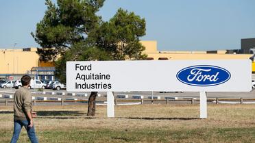 Un homme passe devant le logo du groupe américain Ford, réinstallé à l'entrée du site de Blanquefort (Gironde), le 31 juillet 2013 [Patrick Bernard / AFP]