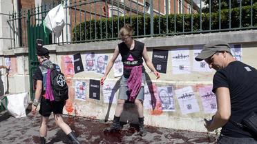 Des militants d'Act Up collent des tracts et répandent un produit simulant du sang devant le siège de la Fondation Jérôme Lejeune, à Paris le 04 août 2013 [Bertrand Guay / AFP]