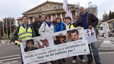 Des amis des quatre otages kidnappés en 2010 au Niger posent devant l'Assemblée nationale, le 16 septembre 2013 à Paris, une étape de leur marche symbolique à travers Paris et sa proche banlieue [Lionel Bonaventure / AFP/Archives]
