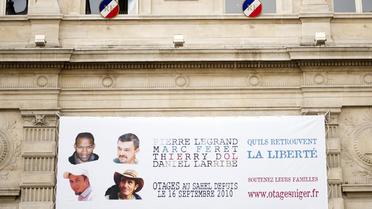 Affiche montrant les quatre otages français enlevés à Arlit au Niger, le 16 septembre 2013 à Paris [Lionel Bonaventure / AFP]