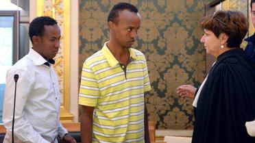 Deux des trois Somaliens jugés à Rennes dans l'affaire de la Tanit parlent avec leur avocate Catherine Glon, le 14 octobre 2013 [Damien Meyer / AFP/Archives]