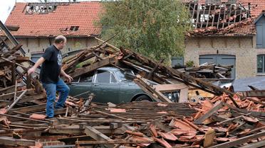 Un homme au milieu des décombres après le passage d'une mini-tornade le 21 octobre 2013 à Bailleul [Philippe Huguen / AFP]