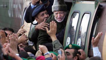 Le leader palestinien Yasser Arafat salue ses partisans alors qu'il monte dans un hélicoptère, le 29 octobre 2004 à Ramallah [Odd Andersen / AFP/Archives]