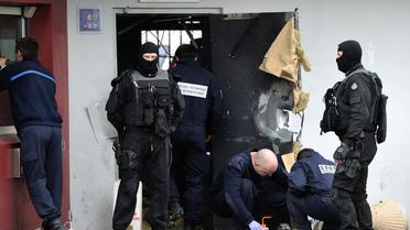 Des officiers de police enquêtent le 13 avril 2013 près de la porte de la prison de Sequedin, détruite par Redoine Faïd lors de son évasion [Philippe Huguen / AFP/Archives]