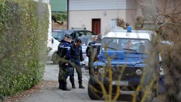 Des gendarmes près de la maison de l'homme arrêté dans le cadre de l'enquête sur la tuerie de Chevaline, à Talloires le 18 février 2014 [Jean-Pierre Clatot / AFP]