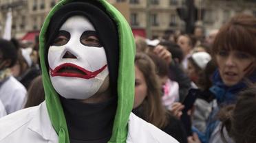 Une sage-femme, masquée, lors d'une manifestation pour le statut des sage-femmes, le 19 février 2014 à Paris [Joel Saget / AFP]