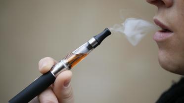 Une personne fume une cigarette électronique [Kenzo Tribouillard / AFP/Archives]