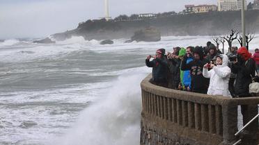 Le rivage balayé par de hautes vagues le 3 mars à Biarritz où des passants prennent de photos [Daniel Velez / AFP]