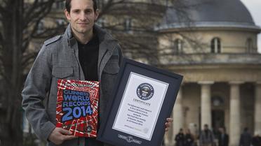 Le perchiste français Renaud Lavillenie, détenteur du record du monde avec 6,16 m, pose avec le livre des records Guinness, le 4 mars 2014 à Paris [Joël Saget / AFP]
