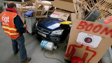 Un employé de l'usine Bosal-le-Rapide à Beine-Nauroy, dans la Marne, devant un grand bûcher installé à l'intérieur des locaux, le 27 mars 2014 [François Nascimbeni / AFP]