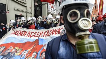 Des manifestants turcs portant des masques à gaz affrontent la police près de la place Taksim, le 1er mai 2014 à Istanbul [Bulent Kilic / AFP]