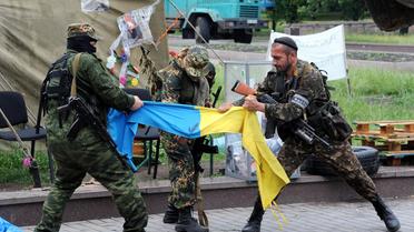 Des miliciens prorusses du bataillon Vostok (Est) déchirent un drapeau ukrainien à Donetsk, le 29 mai 2014 [Viktor Drachev / AFP]