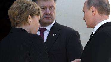 Le président ukrainien Piotr Porochenko (c) s'entretient avec le président russe Vladimir Poutine et la chancelière allemande Angela Merkel, lors de l'anniversaire du Débarquement le 6 juin 2014 au Chateau de Benouville [Saul Loeb / AFP]