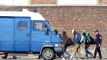 Des policiers français conduisent des clandestins expulsés de leur camp à Calais pour les amener dans un centre de rétention, le 2 juillet 2014 [Denis Charlet / AFP]