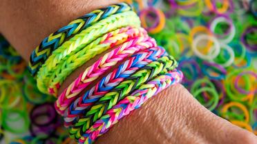 Les bracelets Rainbow Loom, petits élastiques multicolores que l'on tisse pour en faire des bracelets, font fureur sur les plages en France [Philippe Huguen / AFP]