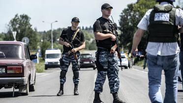 Des militants prorusses bloquent le convoi d'experts médico-légaux et policiers néerlandais et australiens voulant se rendre sur le site du crash du MH17, le 28 juillet 2014 à Donetsk  [Bulent Kilic  / AFP]