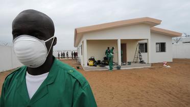 Un homme portant un masque de protection devant un centre de quarantaine pour les personnes atteintes du virus Ebola à l'aéroport d'Abidjan, le 12 août 2014 [Sia Kambou / AFP]
