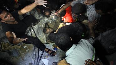 Des secouristes tentent d'extraire des décombres de sa maison un Palestinien blessé le 19 août 2014 à Gaza [Ezz Al-Zanoun / AFP]