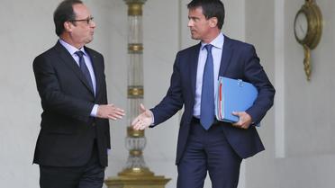 François Hollande et Manuel Valls se serrent la main à la sortie du conseil des ministres le 20 août 2014 sur le perron de l'Elysée à Paris [Patrick Kovarik / AFP]
