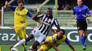 Le milieu français de la Juve Paul Labile Pogba est taclé par un défenseur du Chievo en ouverture du championnat italien, le 30 août 2014 au stade Bentegodi  à Vérone  [ / AFP]