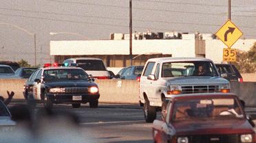 Une voiture de police poursuivant une Ford Bronco avec le fugitif O.J. Simpson à son bord,  le 17 juin 1994 à Los Angeles [Mike Nelson / AFP]