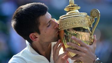 Le Serbe Novak Djokovic embrassant le trophée de Wimbledon le 6 juillet 2014 au All England Tennis Club à Wimbledon, sud-ouest de Londres. [Carl Court / AFP]