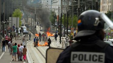 Un policier près de barricades en feu à Sarcelles le 20 juillet 2014 [Pierre Andrieu / AFP]