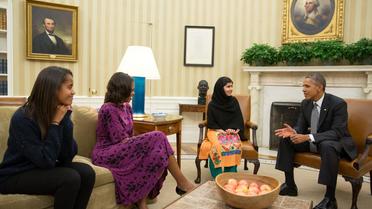 Photo fournie par la Maison Blanche montrant Malala Yousafzai le 12 octobre 2013 entre Michelle et Barack Obama dans le bureau ovale à la Maison Blanche à Washington. A gauche: leur fille Malia [Pete Souza / Maison Blanche/AFP]