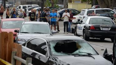 La police barre le passage sur le lieu où a été retrouvée la voiture accidentée de la personne qui a tiré et tué six autres personnes dans les rues d'une ville universitaire de Californie, smaedi 24 mai 2014 [Robyn Beck / AFP]