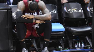 Le joueur des Miami Heat LeBron James sur le banc après avoir été frappé par une crampe lors du match N.1 de la finale NBA contre les San Antonio Spurs, le 5 juin 2014 à San Antonio [ / AFP]