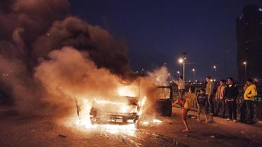 Des manifestants brûlent un véhicule de police au Caire, le 4 mars 2013 [Gianluigi Guercia / AFP]