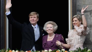 Le roi Willem-Alexander, sa mère Beatrix, et son épouse la reine Maxima saluent la foule, le 30 avril 2013 à Amsterdam [Patrick Stollarz / AFP]