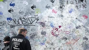 Des policiers gardent un pan du Mur de Berlin retiré de la East Side Gallery, le 27 mars 2013 [John Macdougall / AFP]
