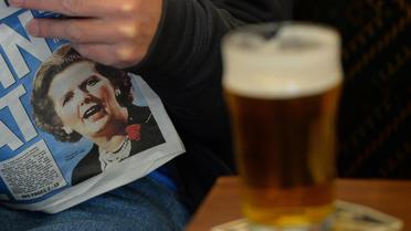 Un homme lit le journal dont la Une est la mort de Margaret Thatcher, le 9 avril 2013 à Armthorpe, dans le Yorkshire [Andrew Yates / AFP]