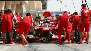 Les techniciens de Ferrari s'activent autour de la F1 du Brésilien Felipe Massa, lors des essais libres du GP de Bahreïn, le 19 avril 2013 [Marwan Naamani / AFP]
