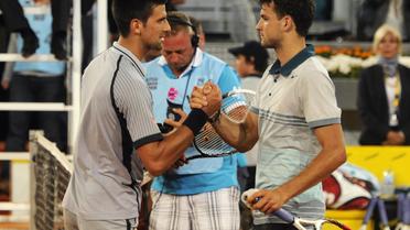 Le Serbe Novak Djokovic (g.) serre la main du Bulgare Grigor Dimitroc (d.) qui l'a battu au 2e tour du tournoi de Madrid à la Caja Magica, le 7 mai 2013. [Dominique Faget / AFP]