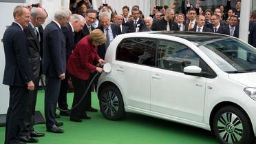 La chancelière Angela Merkel branche une voiture électrique, le 27 mai 2013 à Berlin, lors d'un congrès international sur l'électromobilité [Johannes Eisele / AFP]