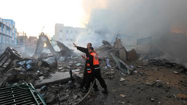 Des Palestiniens éteignent un incendie après des frappes israéliennes sur le bâtiment du ministère de l'Intérieur du Hamas, le 16 novembre 2012 à Gaza [Mahmud Hams / AFP]